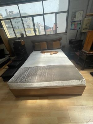 un lit sur lequel est posé un matelas, dans une chambre