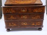 a wooden chest of drawers with a decorative design on it