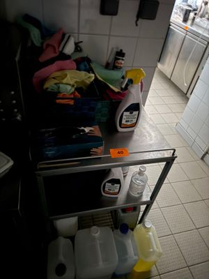a metal cart with cleaning products on it in a kitchen