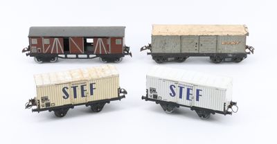 four toy train cars are lined up in a row on a white surface