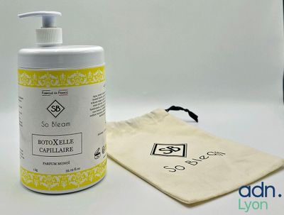 une bouteille de liquide posée à côté d'un sac sur une table