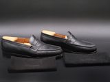 une paire de mocassins noirs posée sur une boîte noire