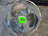 un ventilateur sur lequel est collé un autocollant vert, posé par terre