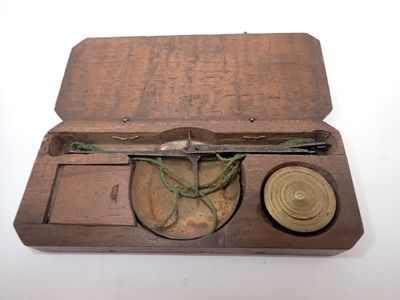 une petite boîte en bois contenant une boussole et un stylo