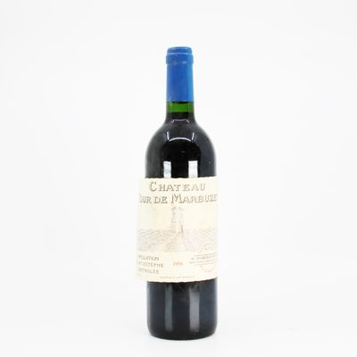 the bottle of wine is sitting on a white surface