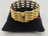a close up of a gold bracelet on a black pillow