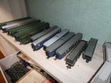 beaucoup de petits trains miniatures posés sur une étagère dans une pièce