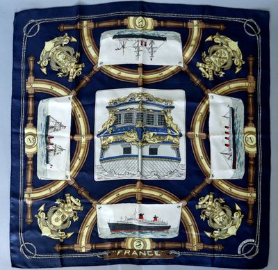 a close up of a square scarf with a ship on it