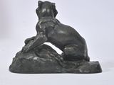 a statue of a dog sitting on top of a rock