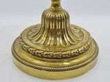 gold plated candle holder on a white surface with a white background