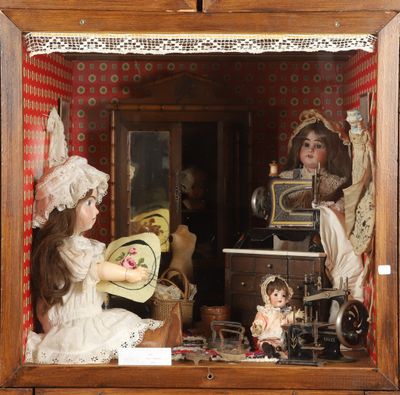 a doll house with dolls in it and a doll in the window