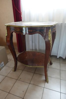 une petite table avec un plateau en marbre posée sur un sol carrelé