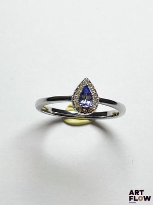 un gros plan d'une bague sertie d'un saphir beige en forme de poire, entouré de diamants