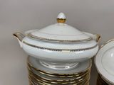 a stack of plates and a bowl with a lid on it