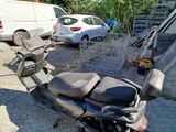 a scooter parked in a parking lot next to a car