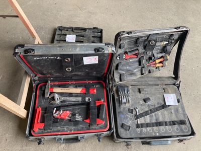 une valise contenant des outils, posée par terre