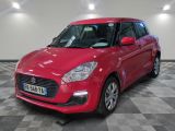 the red suzuki swift is parked on a checkered floor