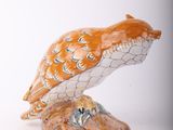 a figurine of an owl sitting on top of a table
