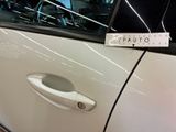 a white car with a sticker on it ' s door handle