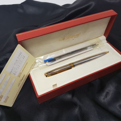 deux stylos dans une boîte rouge posée sur un tissu noir