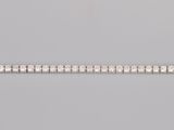 a close up of a silver bracelet on a gray surface