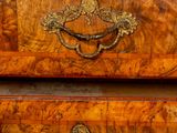 a wooden chest of drawers with brass hardware on the drawers