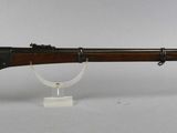 an old rifle with a wooden barrel and a metal stand