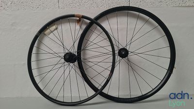 une paire de roues noires à rayons sur un fond blanc