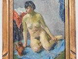 une image représentant un tableau d'une femme nue assise sur une couverture bleue