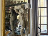 a statue of a man holding a gun in front of a mirror