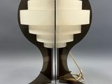 une lampe de table noire surmontée d'un abat-jour blanc