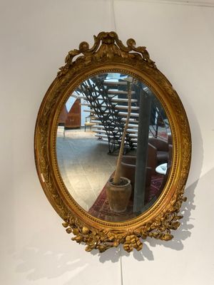 Miroir de forme ovale en bois mouluré et pâte patiné doré à …