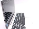a white laptop with a black keyboard on a white surface