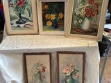 trois tableaux encadrés représentant des fleurs posées sur une table recouverte d'une nappe blanche