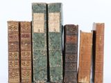plusieurs vieux livres sont empilés sur une surface blanche