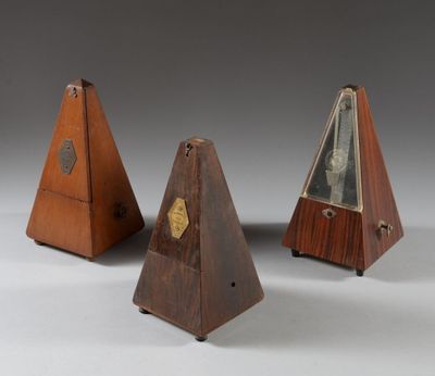 trois pyramides en bois, chacune surmontée d'une horloge