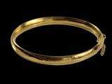 gros plan d'un bracelet en or sur fond noir