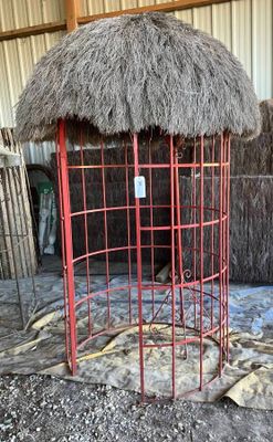 une cage rouge au toit de chaume, dans une grange
