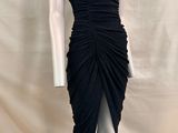 le mannequin porte une robe noire avec une fente haute