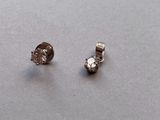 pair of diamond earrings on a table with a white background