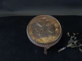 an old clock sitting on a black surface next to a broken clock