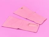 une paire de gants roses sur un fond rose