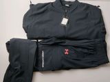 un gros plan d'une veste et d'un pantalon noirs posés sur une surface blanche