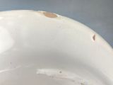 a close up of a white bowl with brown spots on it