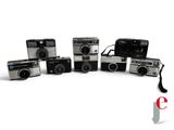five cameras sitting next to each other on a white surface