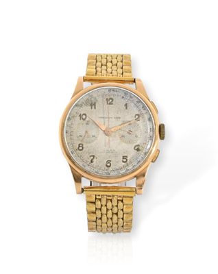 gros plan d'une montre-bracelet en or sur une surface blanche