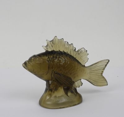 a glass fish figurine sitting on a white surface