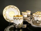 several cups and saucers are sitting on a black table
