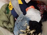 a pile of clothes that is on a couch
