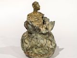 statue représentant un homme assis sur un rocher, tenant un oiseau dans la main